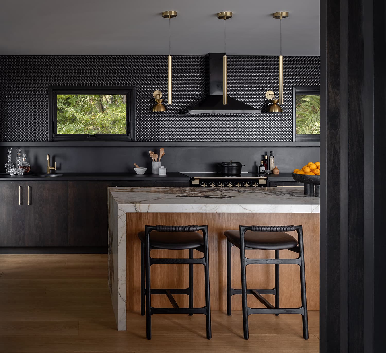 Kitchen island with bar stools, penny tile backsplash, and range hood