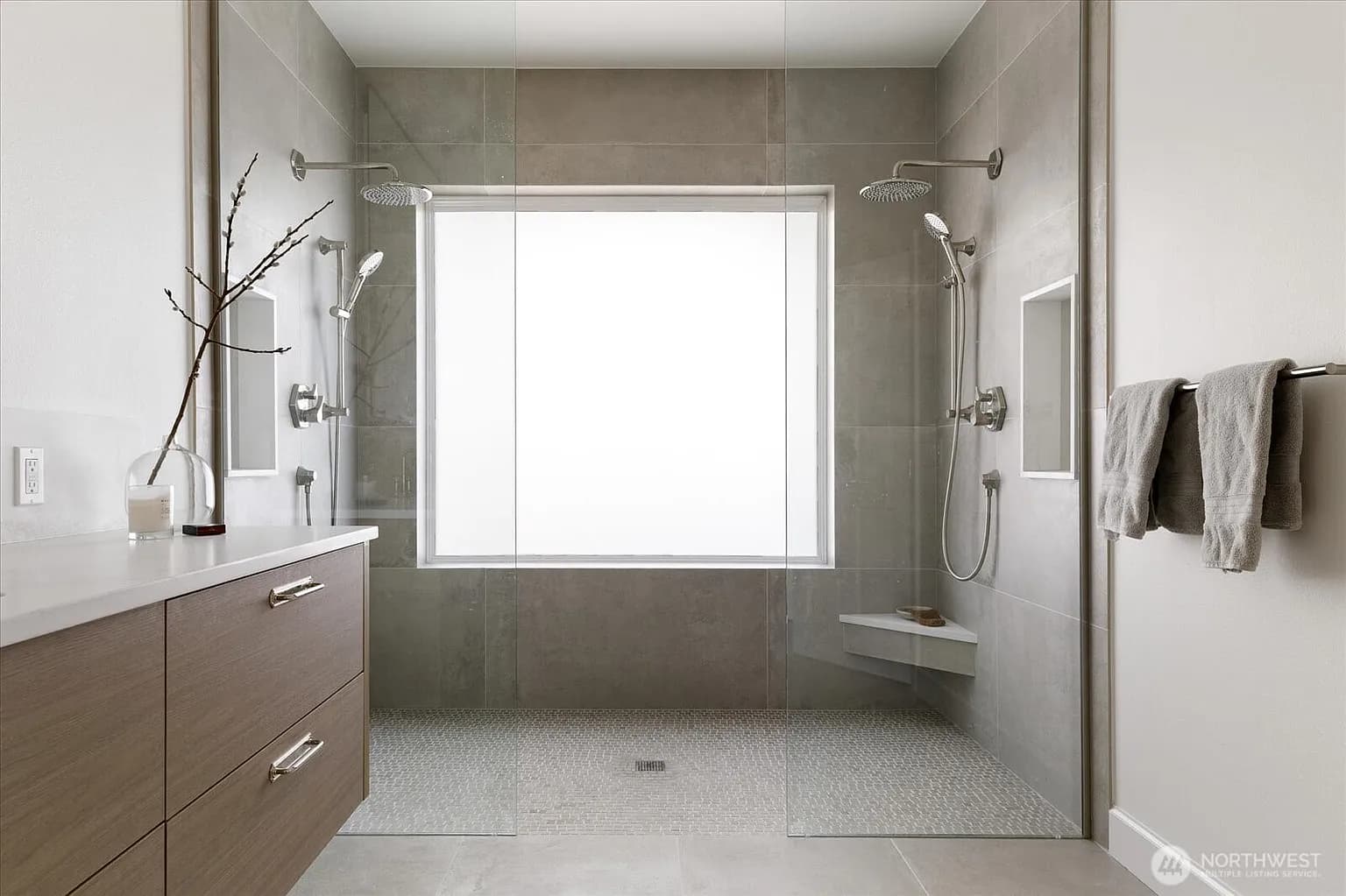 Master shower with dual rain heads, frosted window, and large format tile