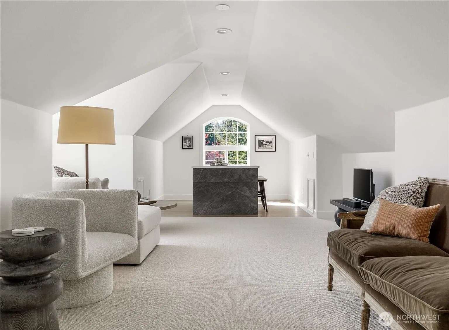 Bonus room with vaulted white ceiling and casual lounge seating